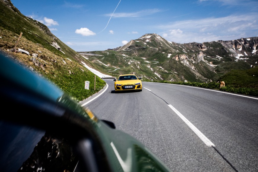 Audi R8 in gelber Farbe von vorne während der Fahrt fotografiert