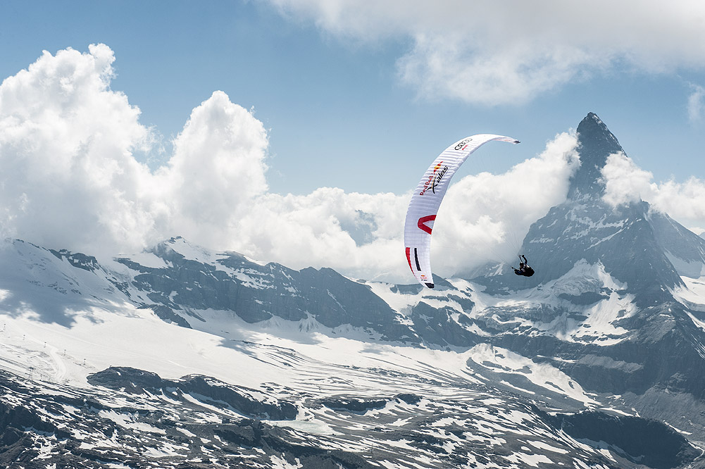 Paragleiter fliegt vor einem eindrucksvollen Bergpanorama